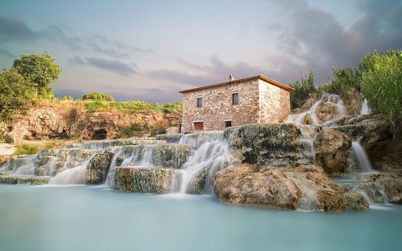 long exposure, waterfront, flowing, plant, scenics - nature, rock - object, architecture, flowing water, building exterior, solid, water, cloud - sky, beauty in nature