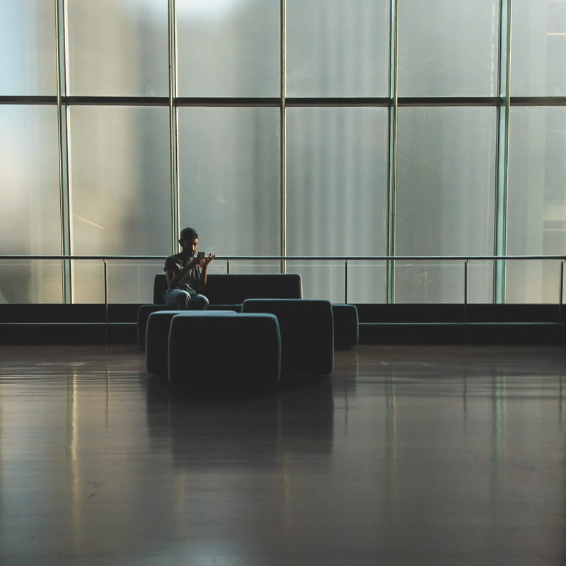 gray, interior design, adult, person, airport, room, wear, black, sitting, 1080P, wireless technology, modern, real people, interior, young, sofa, glass windows