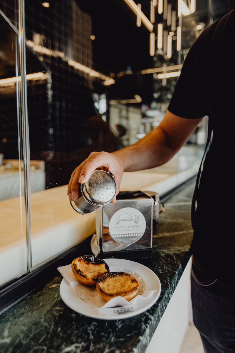 standing, pastel, tray, lifestyles, cafeteria, plate, holding, one person, dessert, food and drink, egg tart, freshness, tart, portuguese, human hand, hand