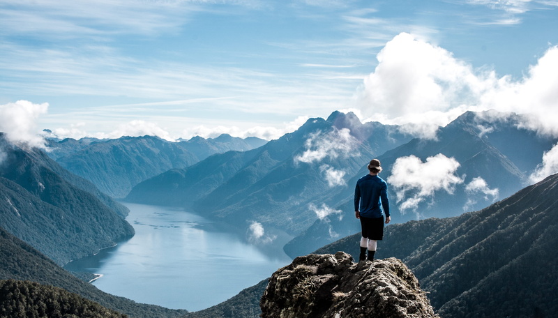 real people, full length, trip, non-urban scene, one person, holiday, vacations, blue, water, mountain, fjord, outdoors, cloud - sky, scenics - nature