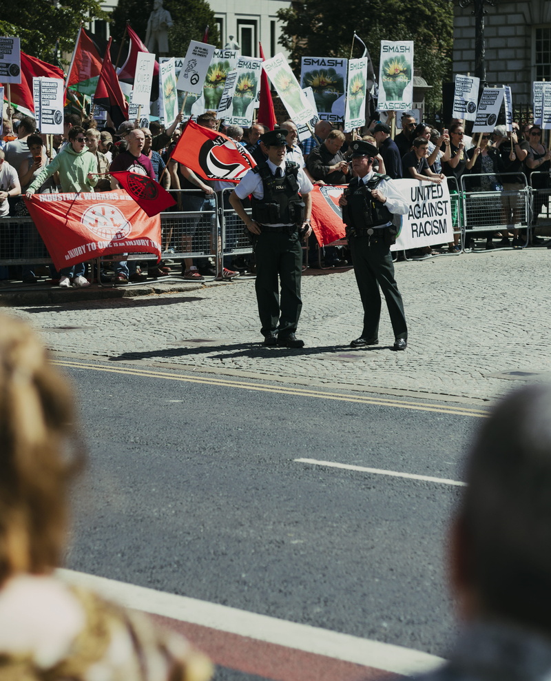 beside, protestor, human, men, government, parade, outdoors, male, city, united kingdom, architecture, protection, person, flag, man, group, fashion, road