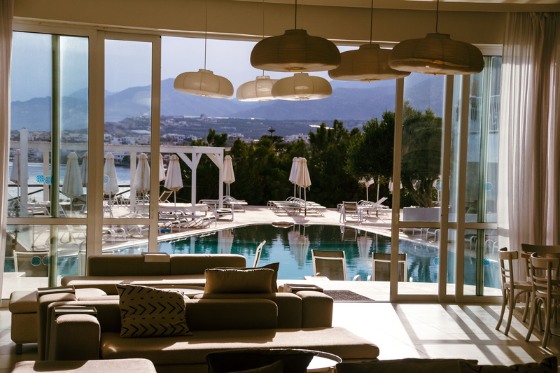wealth, dining table, couch, transparent, turned, seat, swimming pool, window, lighting equipment, cafe, luxury, indoors, tourist resort, absence, doorway