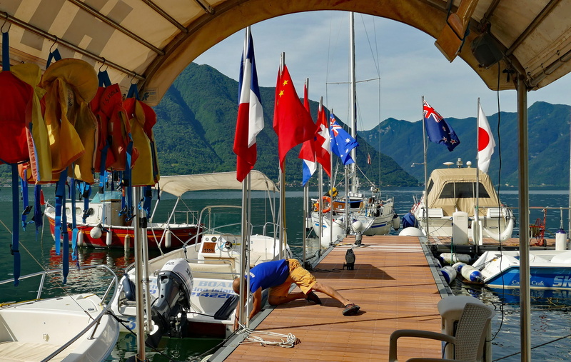 architecture, mode of transportation, water, red, jetty, built structure, flags, flag, moored, powerboat, incidental people, summer, land vehicle, lake