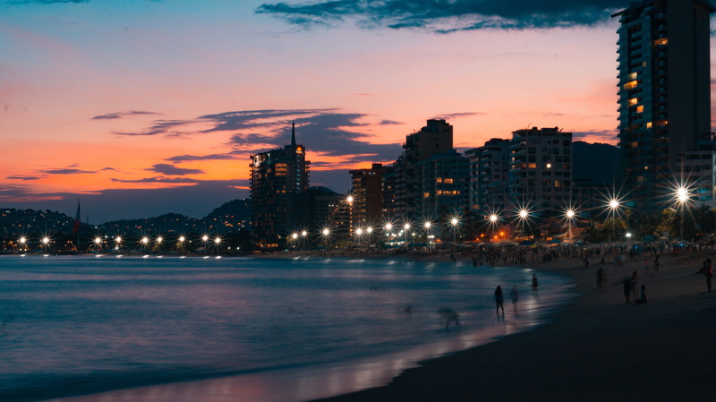 sun, outdoors, beach, sea, hotel, office building exterior, cityscape, acapulco, dusk, sunny, nature, illuminated, ocean, evening, city, orange color, architecture