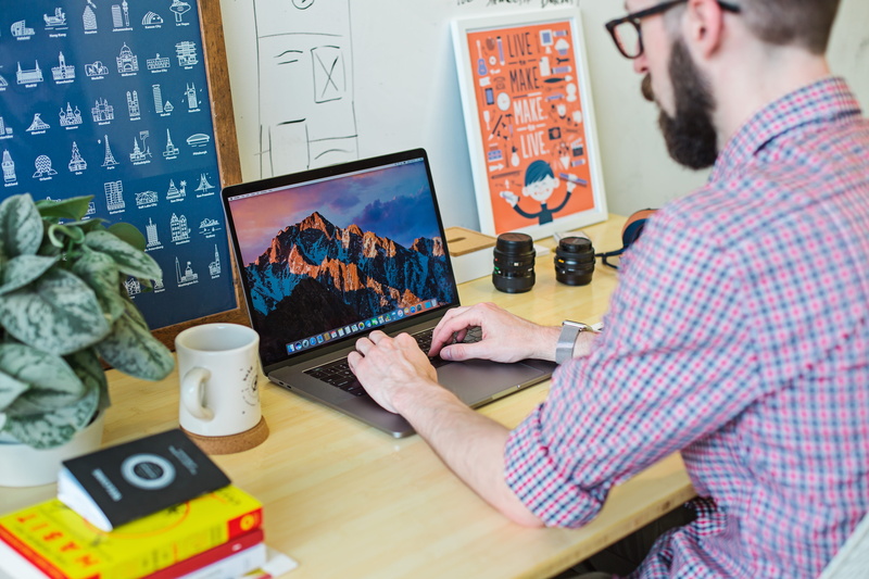 indoors, design, wearing, screen, designer, man, electronic, using, table, daytime, laptop, mac, shirt, business person, design professional, males, young adult