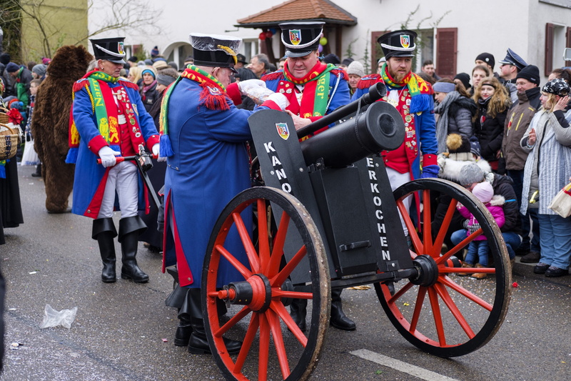 gun, red, group of people, moving truck, uniform, panel, arts culture and entertainment, full length, people, parade, foolish, event, city, costume, day