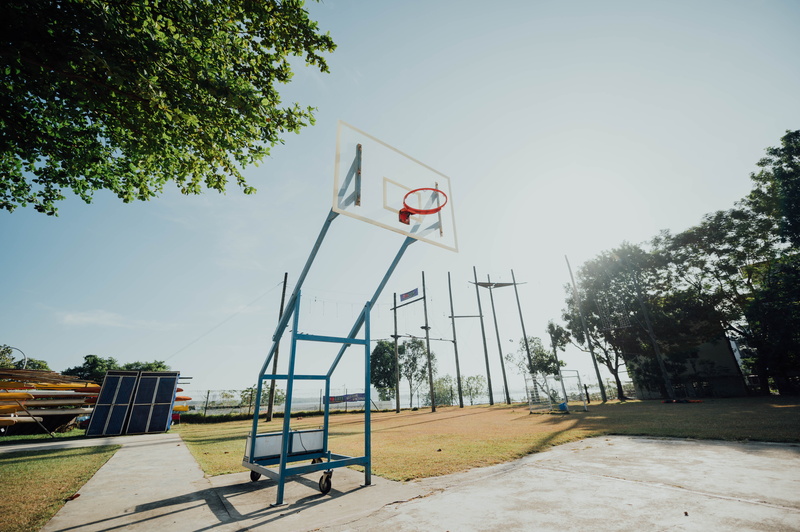 flag, vegetation, basketball, clear sky, growth, footpath, playground, sports, patriotism, plant, park, face, team sport, bench, outdoors, basketball court