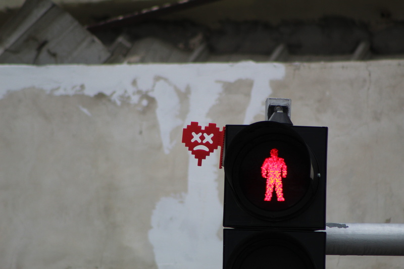headlight, focus on foreground, urban, stoplight, parliament, city, sign, safety, outdoors, light, red, symbol, town, close-up, communication, human, gate
