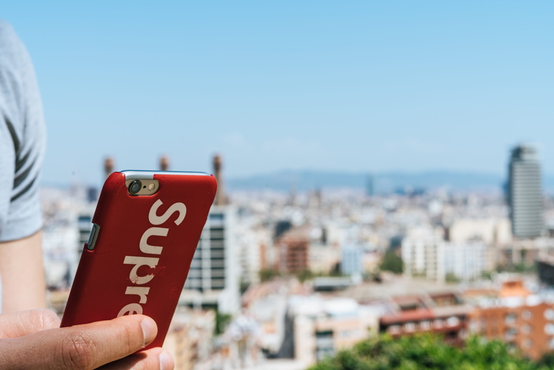 8K, outdoor, body part, supreme iphone case, red, city, guy, building exterior, sky, human body part, style, supreme new york, building, nature, one person