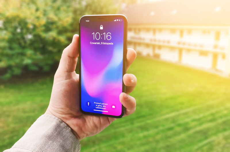 text, space, android, one person, iphone, portable information device, grass, person, smart phone, outdoors, holding, communication, phone, western script