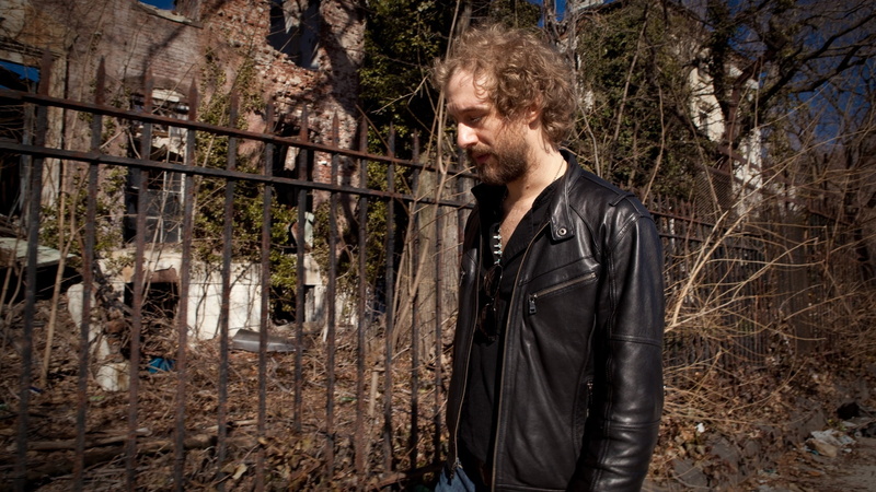 young men, fence, young adult, contemplation, standing, 1080P, one person, waist up, forest, sunlight, leather jacket, s, casual clothing, black, leather