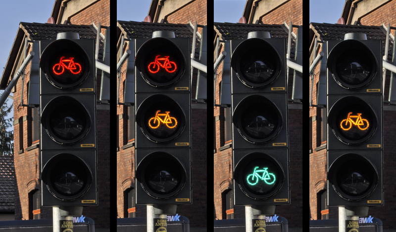 in a row, audio equipment, red, day, appliance, traffic, design, signal, outdoors, light, nature, city, transportation, shape, sign, street, road, bicycle