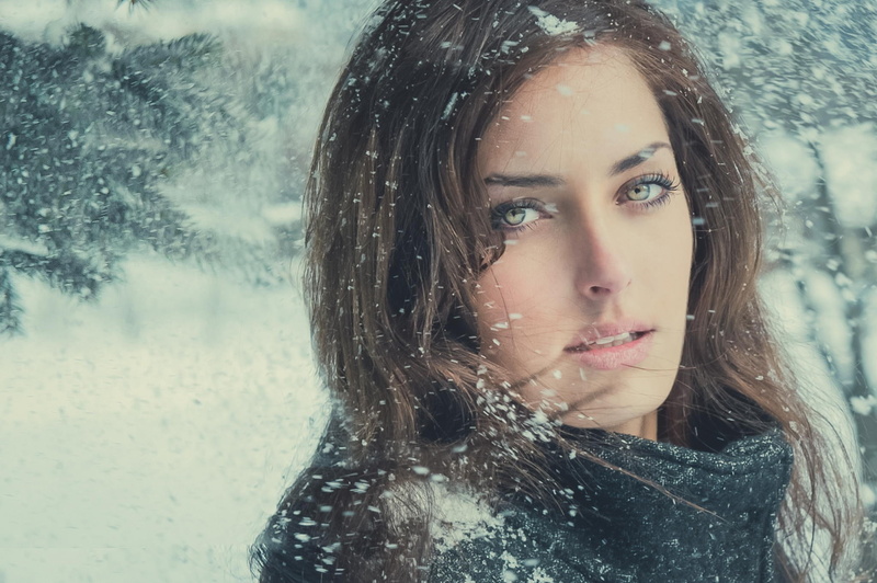 looking at camera, black coat, winter, extreme weather, one person, long hair, headshot, tree, beautiful woman, snowing, model, photo, outdoors, pale, focus on foreground