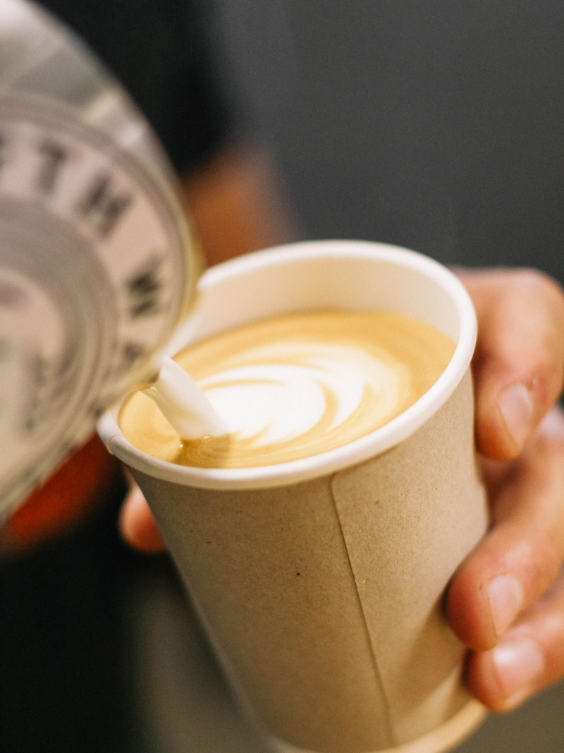 milk, coffee - drink, human limb, cup, takeaway, coffee cup, holding, drink, indoors, coffee bean, lifestyles, pour, food and drink, hot drink, latte art