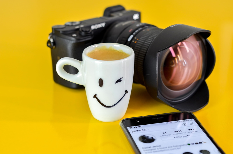 cell phone, camera, activity, headset, technology, headphones, mug, communication, no people, close-up, black color, photographic equipment, finger, lens cap