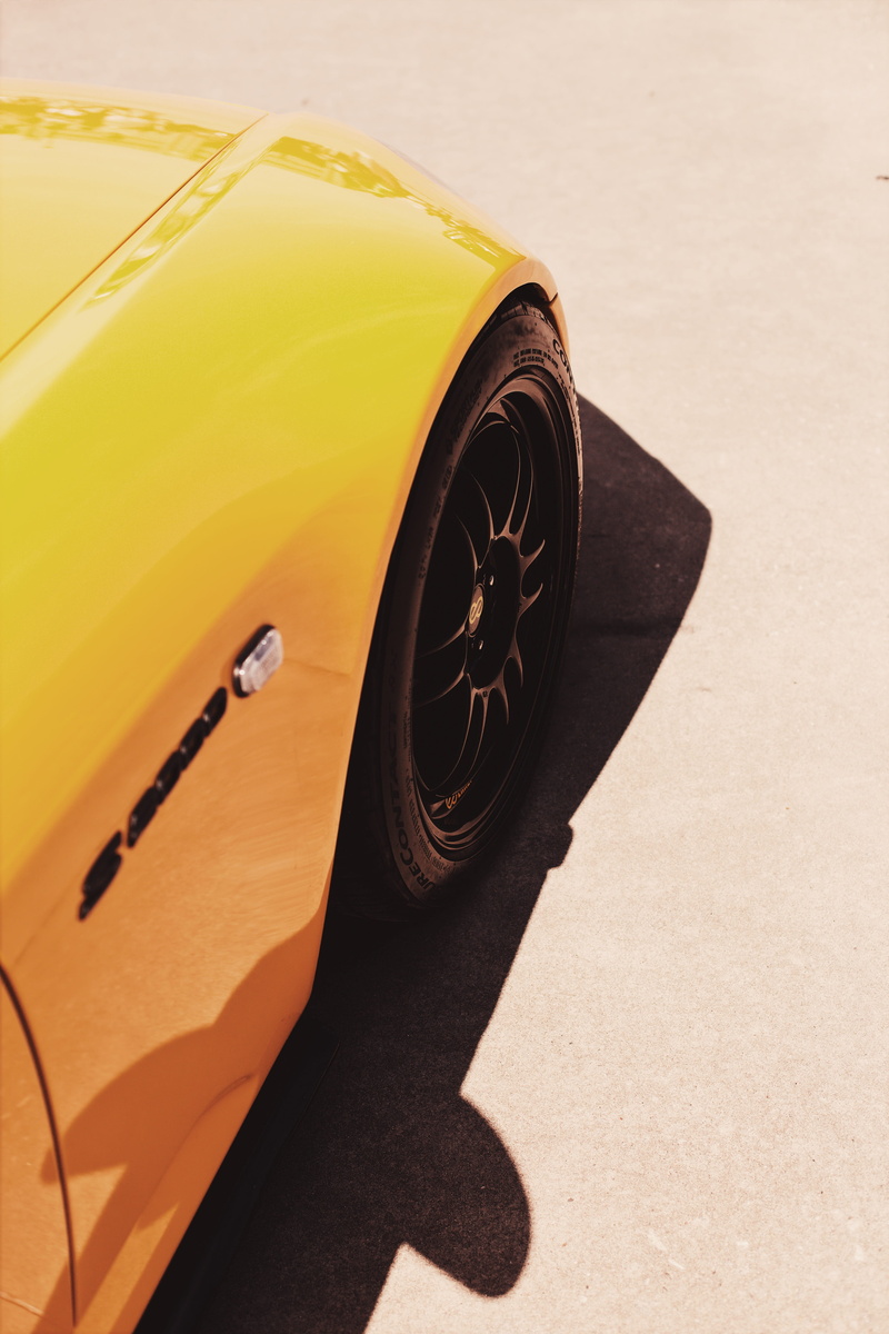 yellow, spoke, alloy wheel, transportation, gray, coffee cup, day, trademark, land vehicle, orange color, close-up, car, leisure activities, hubcap, tire