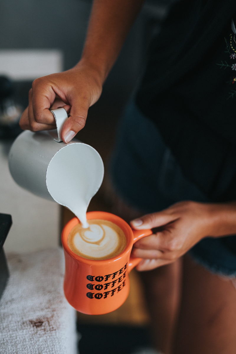 orange mug, cup, coffee cup, indoors, coffee coffee, preparation, hand, drink, midsection, food and drink, 5K, one person, latte art, refreshment, caffeine