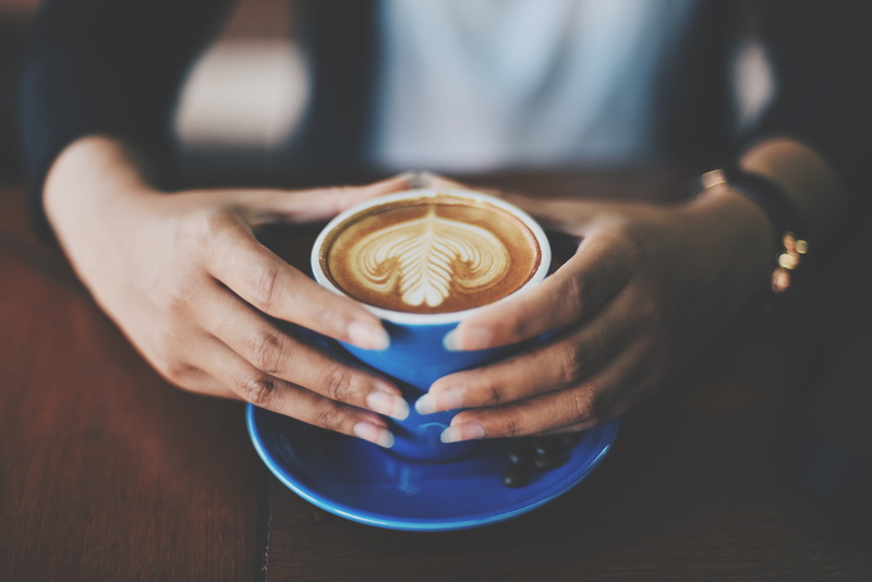 person, espresso, cappuccino, food and drink, human hand, mug, human body part, caffelatte, latte, hot drink, table, cafe, coffee - drink, hand, art, cup