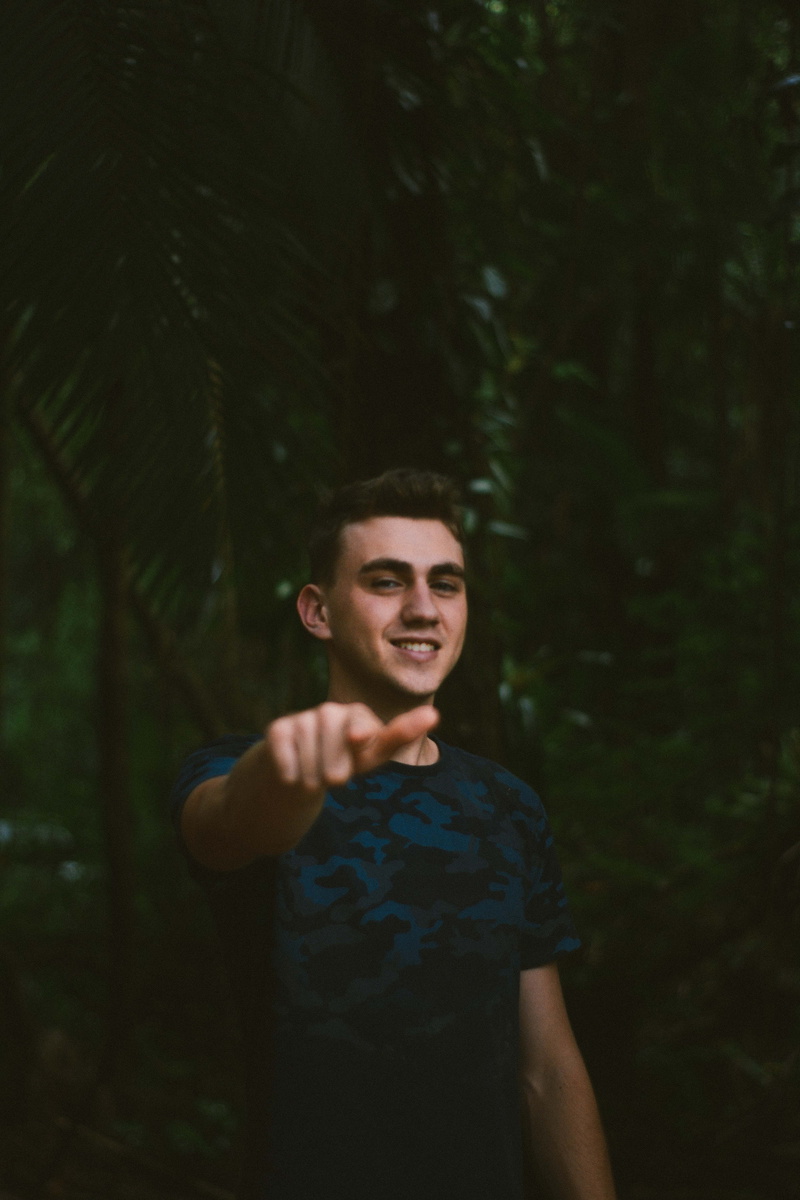 man, leisure activity, 5K, lifestyles, standing, tree, pointing, front view, one person, forest, looking at camera, facial expression, fine-looking, happy