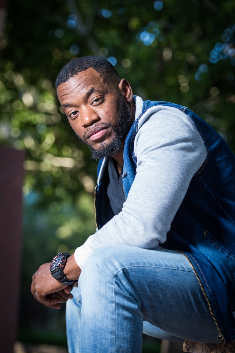 outdoors, eye contact, leisure activity, three quarter length, day, watch, african american, young men, man, wearing, jacket, seating, adult, shallow, real people