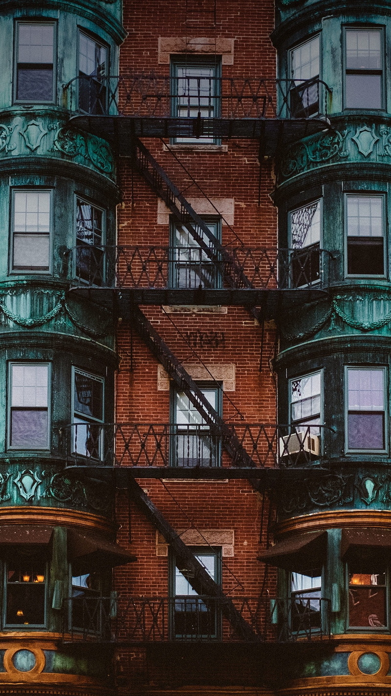 outdoors, building exterior, brick wall, apartment, residential district, built structure, railing, wall, fire escape, Symmetry, architecture, urgency