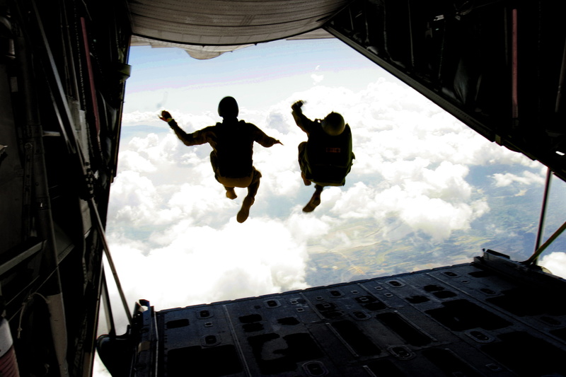 human arm, flight, mid-air, cloud - sky, military, architecture, training, excitement, exhilaration, real people, parachute, outdoors, sky, day, low angle view