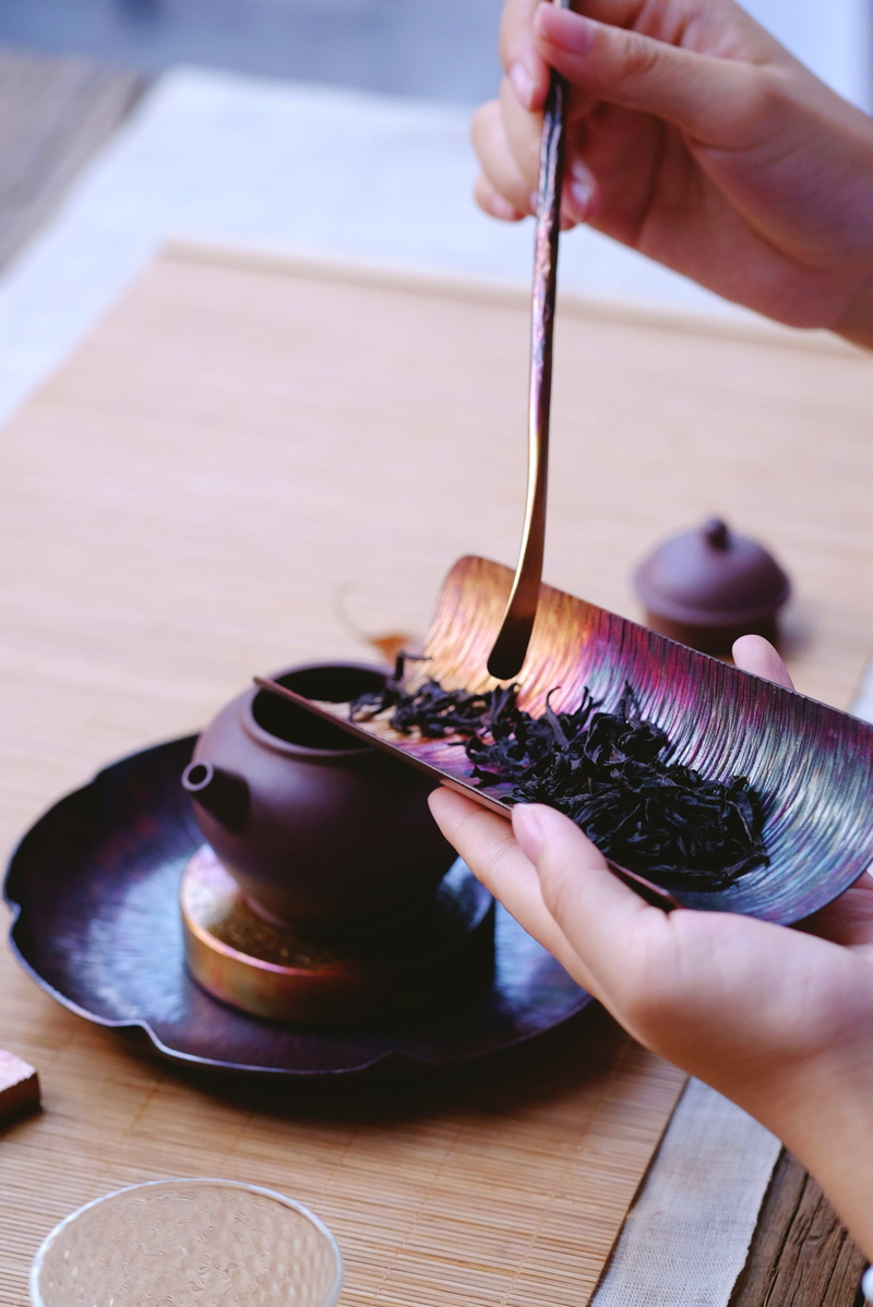 craft, loose leaf, focus on foreground, brass, plate, real people, human hand, human body part, paper, occupation, tea leaves, tool, person, 2K, purple