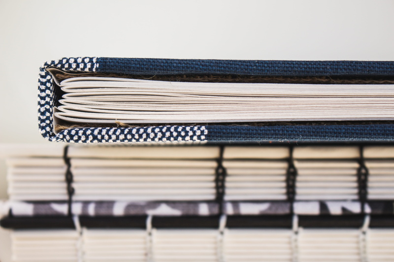 arrangement, focus on foreground, hand stitched, folded, minimal, order, large group of objects, striped, textile, indoors, close-up, book stack, bookbinding