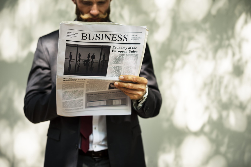 man, standing, real people, person, newspaper, one person, day, paper, suit, male, lifestyles, western script, adult, focus on foreground, wall, document