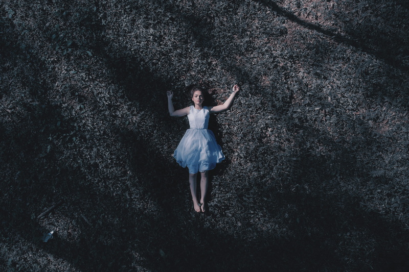 emotion, grass, one person, young adult, full length, laying, arms raised, leisure activity, ground, person, outdoors, casual clothing, human limb, woman