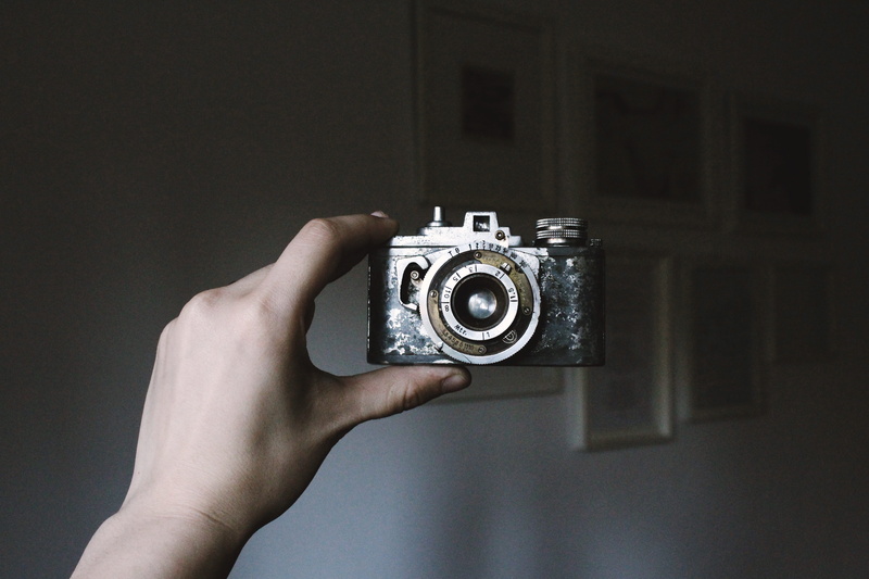 retro Styled, camera - Photographic Equipment, single Object, human Hand, indoors, one person, focus on foreground, equipment, Film, 5K, old, lifestyles