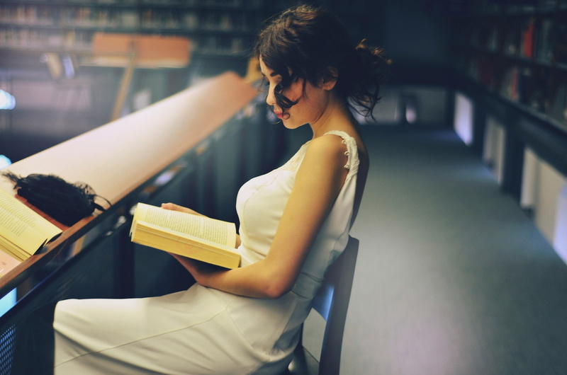 hairstyle, book, young adult, seat, studying, sitting, books, beauty, three quarter length, real people, one person, focus on foreground, casual clothing