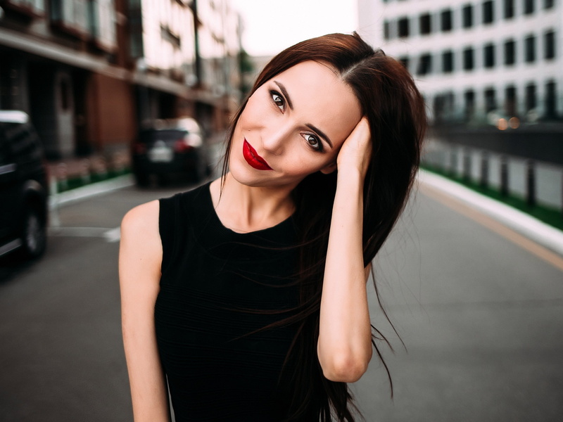 hair, hands on head, black color, smiling, fashion, red lipstick, looking at camera, beautiful woman, one person, face, focus on foreground, architecture