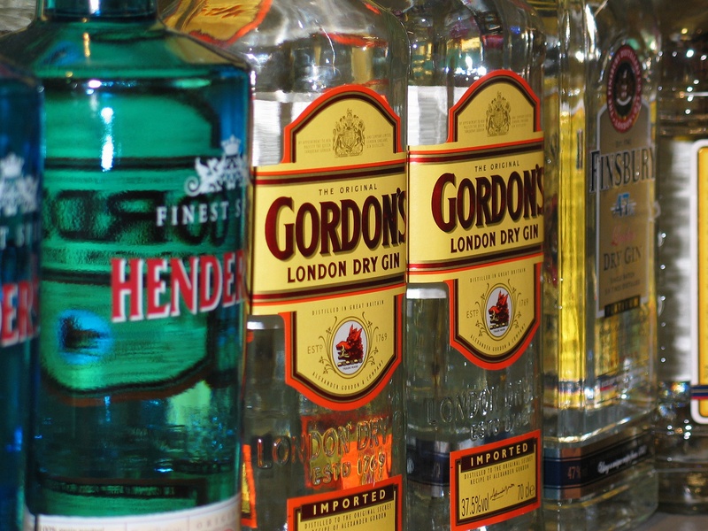 sign, reflection, party, culture, western script, sale, alcohol, gordon, label, communication, club, dry, bar, food and drink, gin, drink, shelf, illuminated