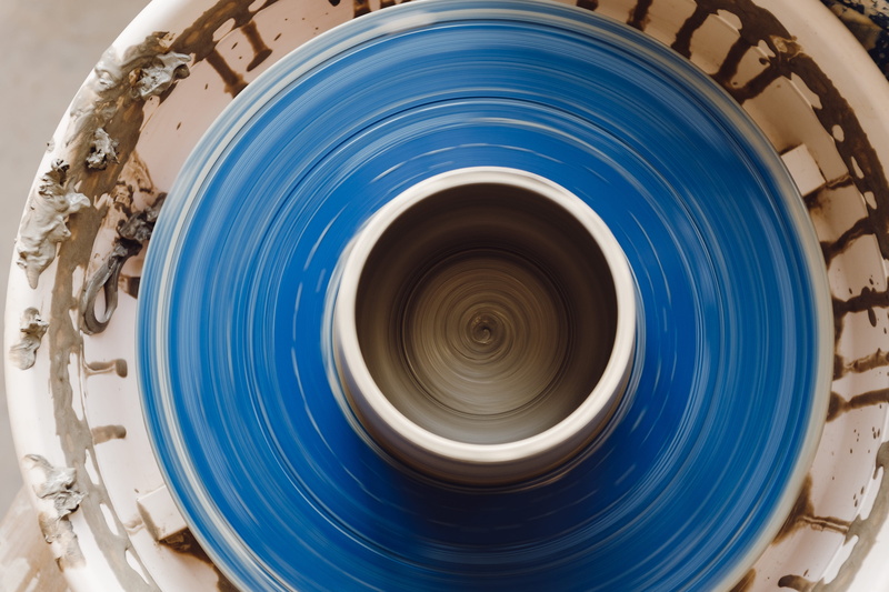 form, industry, spinning, geometric shape, making, ceramic, workshop, pot, artist, wet, craft, no people, day, indoors, bowl, blue, shaping, directly above