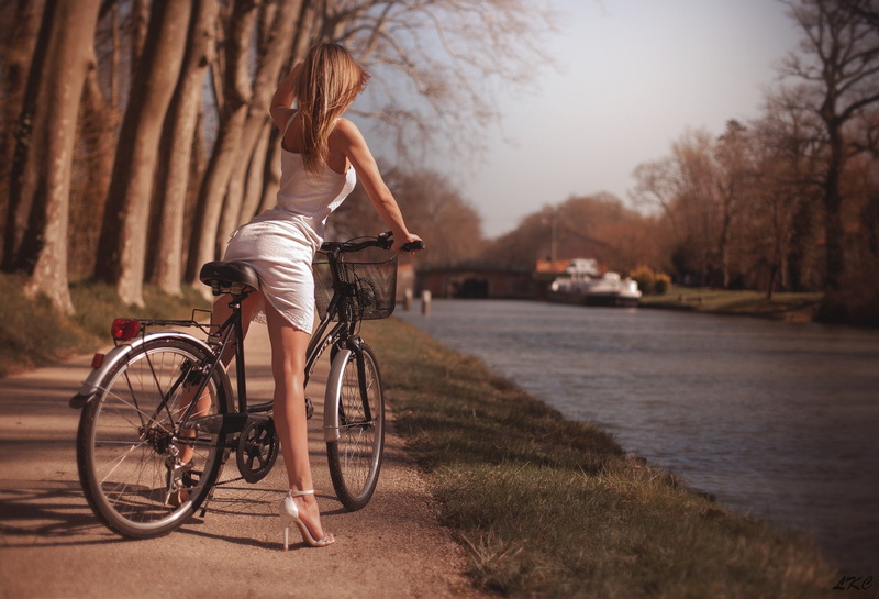 trees, river, Park, bokeh, sexy, figure, dress, nature, legs, the sun, in white, hairstyle, brown hair, shoes, pose, girl, bike, 1080P