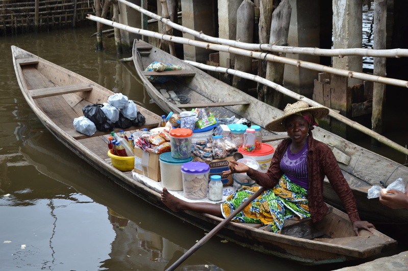 africa, mode of transportation, lake, day, portrait, nature, saleswoman, one person, high angle view, water, clothing, river, group, built structure, sitting