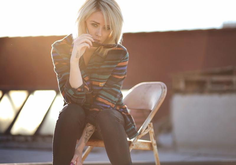 young women, front view, outdoors, three quarter length, contemplation, adult, blond hair, lips, lens flare, sitting, one person, hairstyle, day, eyes