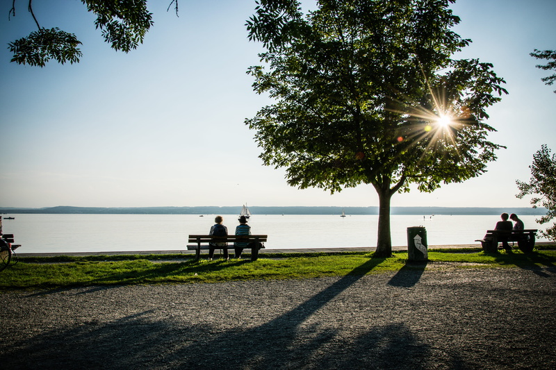 park, lake, bench, 5K, sitting, real people, day, sunny, boats, sunlight, grass, water, outdoors, transportation, two people, plant, adult, promenade