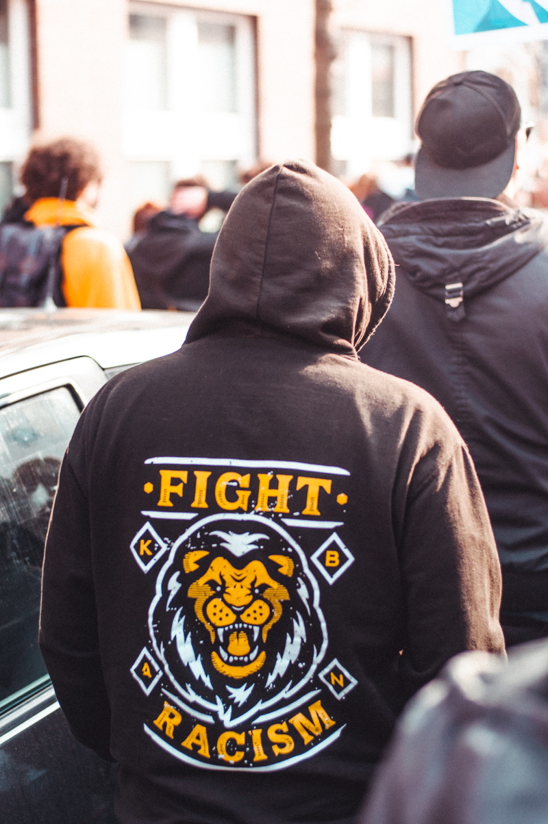 focus on foreground, real people, men, stop racism, cap, apparel, back, berlin, lion, group of people, fight racism, demonstration, day, outdoors, hood