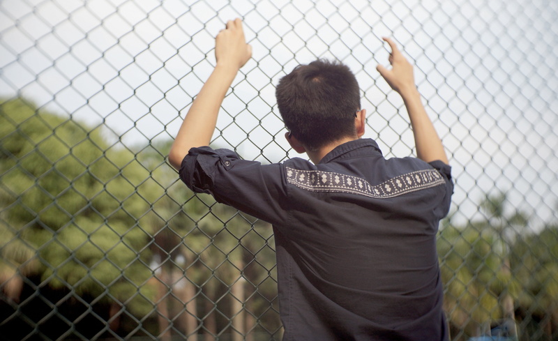 network wall, men, chainlink fence, boring, barrier, human limb, grid, one person, relying on, afternoon, protection, 4K, ao, leisure activity, fence