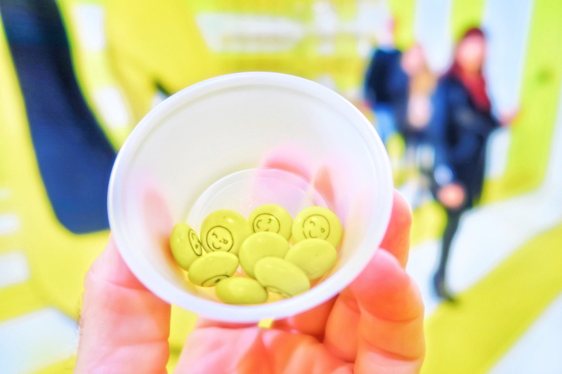 candies, day, colors, human body part, adorable, chocolate, finger, black and yellow, pop, indoors, bright, colorful, focus on foreground, wink, food and drink