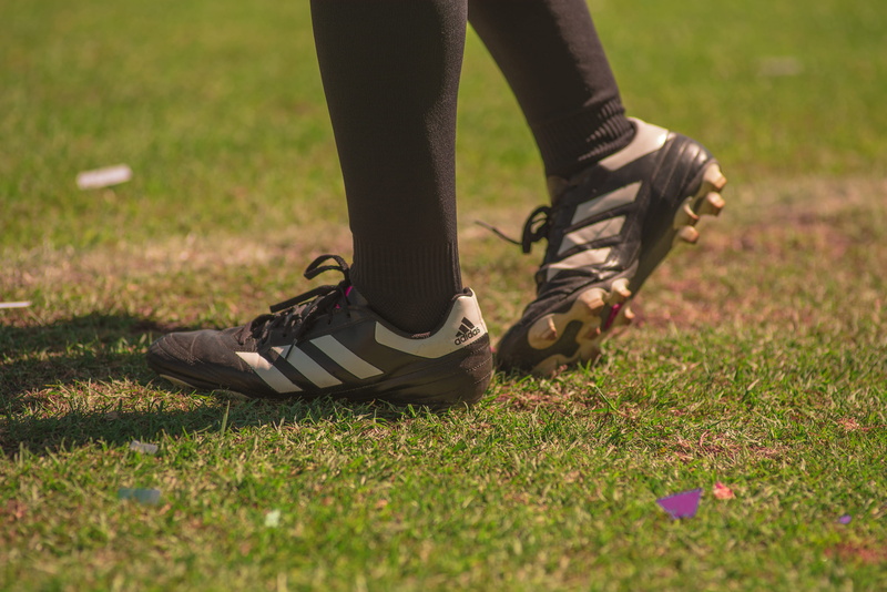 human body part, grass, black, standing, one person, shoe, selective focus, lifestyles, gray, adidas, human leg, adult, person, wearing, nature, day, plant