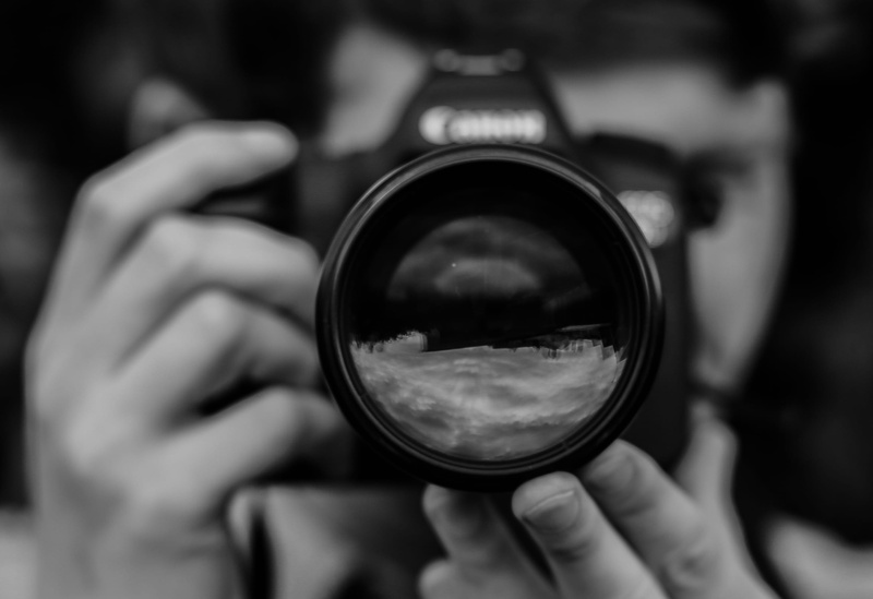 looking through an object, technology, photographing, 2K, holding, glass - material, one person, digital camera, photography themes, focus, close-up, camera - photographic equipment