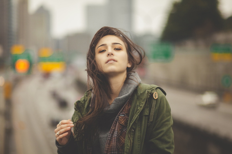 leather, beauty, holding hair, warm clothing, clothing, 1080P, real people, jacket, city, looking, day, scarf, focus on foreground, contemplation, front view