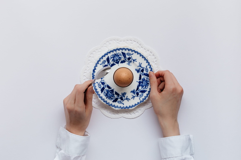 caucer, cup, stainless, mug, man, holding, Eating, one person, Hard Boiled Egg, drink, studio shot, hand, 2K, doily, egg, refreshment, blue, high angle view