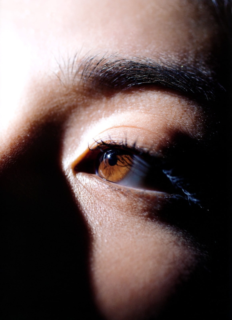 eyebrow, mystery, black background, young adult, eyesight, looking at camera, portrait, human body part, eyelash, contemplation, extreme close-up, close-up