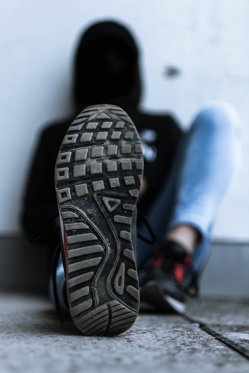 alloy wheel, sneaker, running shoe, covered, low section, leisure activity, sitting, sports equipment, streetphotography, casual clothing, black, wearing