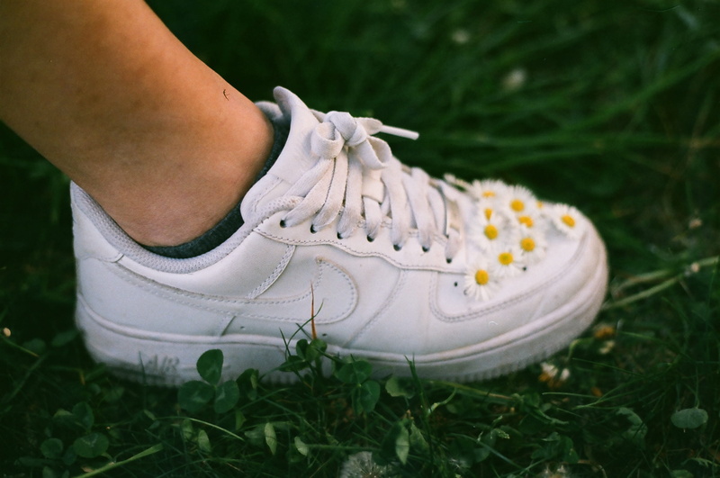 nike, shoelace, plant, 2K, grass, leisure activity, photo, white color, field, flowers, one person, shoes, real people, body part, plants, focus on foreground