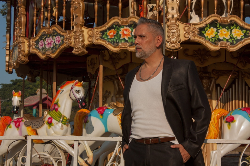 waist up, three quarter length, adult, person, day, theme park, mature, latino, clothing, overcoat, human representation, one person, young adult, horse